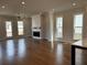 Spacious living room featuring hardwood floors, a modern fireplace, and natural light from large windows at 173 Basil St, Cumming, GA 30040