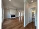 An open living area with fireplace, hardwood floors, a ceiling fan, and access to a half bathroom at 173 Basil St, Cumming, GA 30040
