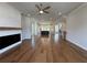 Open-concept living area featuring hardwood floors, a modern fireplace, and a glimpse of the kitchen at 173 Basil St, Cumming, GA 30040