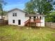 Backyard with a wooden deck, white siding, and a fenced-in yard with mature trees at 2067 Wellborn Close, Lithonia, GA 30058