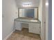 Bathroom vanity area with a built-in mirror, ample storage, and neutral tiling at 2067 Wellborn Close, Lithonia, GA 30058