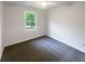 Cozy bedroom with neutral walls, carpet flooring, and a bright window providing natural light at 2067 Wellborn Close, Lithonia, GA 30058