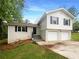 Charming two-story home with a white brick facade and a two-car garage and black shutters at 2067 Wellborn Close, Lithonia, GA 30058
