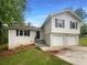Charming two-story home with a white brick facade and a two-car garage and black shutters at 2067 Wellborn Close, Lithonia, GA 30058