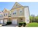 Charming two-story townhome features a brick facade, gray siding, manicured lawn and attached garage at 4925 Longview Walk, Decatur, GA 30035