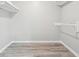 Minimalist closet with neutral walls, floating shelves, and modern wood-look flooring at 2930 Parc Lorraine, Lithonia, GA 30038