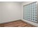 Bedroom view featuring stylish wood floors and natural light from unique glass block window at 390 17Th Nw St # 5008, Atlanta, GA 30363