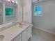 Bathroom featuring a large mirror, a double vanity and a window above the tub at 156 Hawthorn Dr, Carrollton, GA 30116