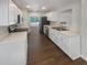 Modern kitchen with stainless steel appliances, bright countertops, white cabinetry, and a view into the living space at 156 Hawthorn Dr, Carrollton, GA 30116