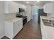 Well-lit kitchen featuring modern appliances, white cabinets, and countertops, with a seamless flow into the adjacent living area at 156 Hawthorn Dr, Carrollton, GA 30116