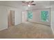 Main bedroom with a ceiling fan and neutral carpeting, featuring two windows providing natural light at 156 Hawthorn Dr, Carrollton, GA 30116