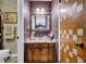 Cozy bathroom showcasing a vanity and patterned wallpaper with unique door design at 2272 Plantation Ct, Lawrenceville, GA 30044