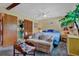 Cozy bedroom featuring a comfy sofa, a closet, a ceiling fan, and a decorative artificial palm tree at 2272 Plantation Ct, Lawrenceville, GA 30044