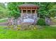 Stone entrance to Great Sky community with wooden gazebo and colorful flowerbeds at 186 Sunshower Rdg, Canton, GA 30114
