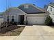 Charming single Gathering home with a two car garage, manicured lawn, and stone details at 186 Sunshower Rdg, Canton, GA 30114