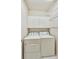 Bright laundry room equipped with side-by-side washer and dryer, overhead cabinets and shelving at 2119 Wrights Mill Ne Cir, Atlanta, GA 30324