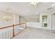 Open loft space with chandelier, neutral carpet and wood railing at 2119 Wrights Mill Ne Cir, Atlanta, GA 30324