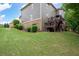 Expansive backyard showcasing a manicured lawn, mature trees, the rear house elevation, and an elevated deck at 3309 Nw Past Nw Pl, Kennesaw, GA 30152