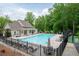 Community pool with lounge chairs and umbrellas near the clubhouse, surrounded by lush greenery at 3309 Nw Past Nw Pl, Kennesaw, GA 30152