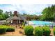 Exterior of the community clubhouse and fenced in pool area with lounge chairs and lush landscaping at 3309 Nw Past Nw Pl, Kennesaw, GA 30152