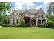 Charming two-story home featuring a well-manicured lawn, stone accents, and a welcoming front porch with rocking chairs at 3309 Nw Past Nw Pl, Kennesaw, GA 30152