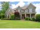 Charming two-story home featuring a well-manicured lawn, stone accents, and a welcoming front porch with rocking chairs at 3309 Nw Past Nw Pl, Kennesaw, GA 30152