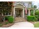 Inviting front porch with stone columns, flag, and manicured bushes leading to the front door at 3309 Nw Past Nw Pl, Kennesaw, GA 30152