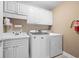 Functional laundry room featuring a modern washer and dryer with cabinets and a sink at 3309 Nw Past Nw Pl, Kennesaw, GA 30152