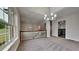 Bright living room with modern chandelier, fresh grey carpet and neutral paint at 3681 Auger Trl, Douglasville, GA 30135