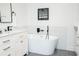 Modern bathroom features a soaking tub, modern fixtures, marble backsplash, and gray tile floor at 1662 Rainier Falls Ne Dr, Atlanta, GA 30329
