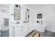 Bright bathroom features double sinks, modern fixtures, a soaking tub, gray tile floor, and artwork at 1662 Rainier Falls Ne Dr, Atlanta, GA 30329