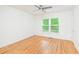 Bright bedroom with hardwood floors, ceiling fan, and sunny windows with wooded view at 1662 Rainier Falls Ne Dr, Atlanta, GA 30329