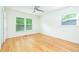Bright bedroom with hardwood floors, ceiling fan, and sunny windows with wooded view at 1662 Rainier Falls Ne Dr, Atlanta, GA 30329