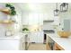 Well-lit kitchen featuring white cabinets, stainless steel appliances, floating shelves, and modern fixtures at 1662 Rainier Falls Ne Dr, Atlanta, GA 30329