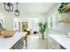 Bright kitchen with open layout, white cabinets, a kitchen island, stylish pendant lighting, and herringbone floors at 1662 Rainier Falls Ne Dr, Atlanta, GA 30329