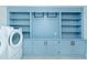 Well-organized laundry area features blue cabinets and open shelves and a washer at 1662 Rainier Falls Ne Dr, Atlanta, GA 30329