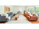 Inviting living room featuring a gray sofa, orange accent chairs, hardwood floors, and plenty of natural light at 1662 Rainier Falls Ne Dr, Atlanta, GA 30329