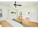 Bright main bedroom with hardwood floors, ceiling fan, bench, and sliding glass doors to a porch at 1662 Rainier Falls Ne Dr, Atlanta, GA 30329