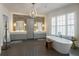 Elegant bathroom with a freestanding tub, dual vanities, herringbone tile floor, and sophisticated lighting at 316 S Esplanade, Alpharetta, GA 30009