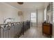 Bright hallway featuring a decorative chandelier, black iron railing, and sophisticated decor elements at 316 S Esplanade, Alpharetta, GA 30009