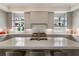 The kitchen island features seating, stainless steel appliances, gray cabinets, and windows at 316 S Esplanade, Alpharetta, GA 30009