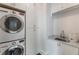 Functional laundry room with modern washer/dryer, sink, and ample storage at 316 S Esplanade, Alpharetta, GA 30009