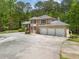 Aerial view of a home with a three-car garage, circular driveway, and lush landscaping at 5302 Greenway Dr, Villa Rica, GA 30180