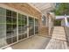 Wooden back deck with sliding glass doors, brick exterior, and staircase leading to a green backyard at 5302 Greenway Dr, Villa Rica, GA 30180
