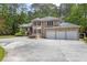 Lovely brick home with a three-car garage and circular driveway surrounded by mature trees at 5302 Greenway Dr, Villa Rica, GA 30180