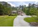 A two-story brick home provides curb appeal with a circular driveway and manicured lawn at 5302 Greenway Dr, Villa Rica, GA 30180