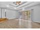 Large living room featuring light hardwood floors, tray ceilings, and a sliding glass door to the outside deck at 5302 Greenway Dr, Villa Rica, GA 30180