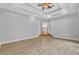 Open-concept living room featuring light hardwood floors, tray ceilings with fan, and staircase to another floor at 5302 Greenway Dr, Villa Rica, GA 30180
