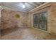 Enclosed patio area featuring a brick floor, metal ornate security door, brick walls, and decorative wall art at 5302 Greenway Dr, Villa Rica, GA 30180
