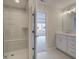 Modern bathroom with tiled shower, vanity with cabinets and large mirror at 1976 Deco Dr, Kennesaw, GA 30144